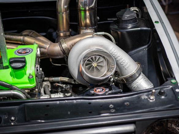 ASA Hochleistungs-Kompressor im Motorraum eines Fahrzeugs mit sichtbarem Turbolader und präziser Edelstahlverrohrung ASA Kompressor